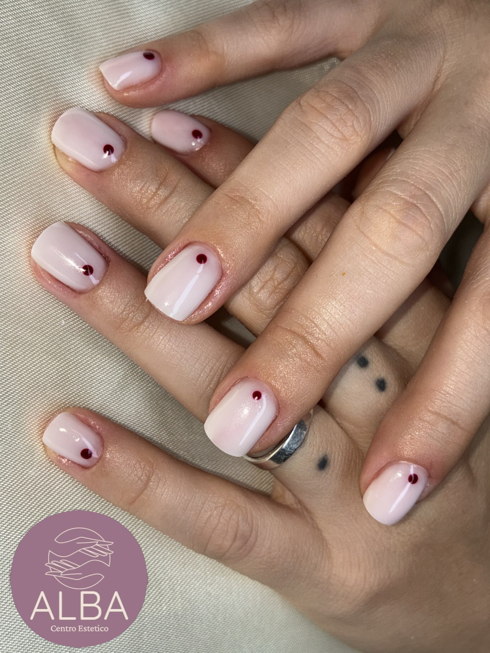 Manicure rosa minimal con piccoli dettagli rossi